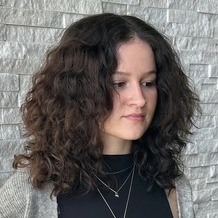 Voluminous natural curls shaped into a soft lob